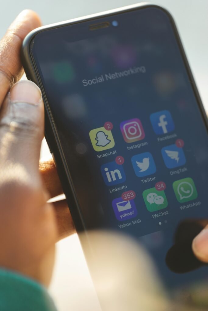 Close-up of a smartphone showing various social media applications being used.